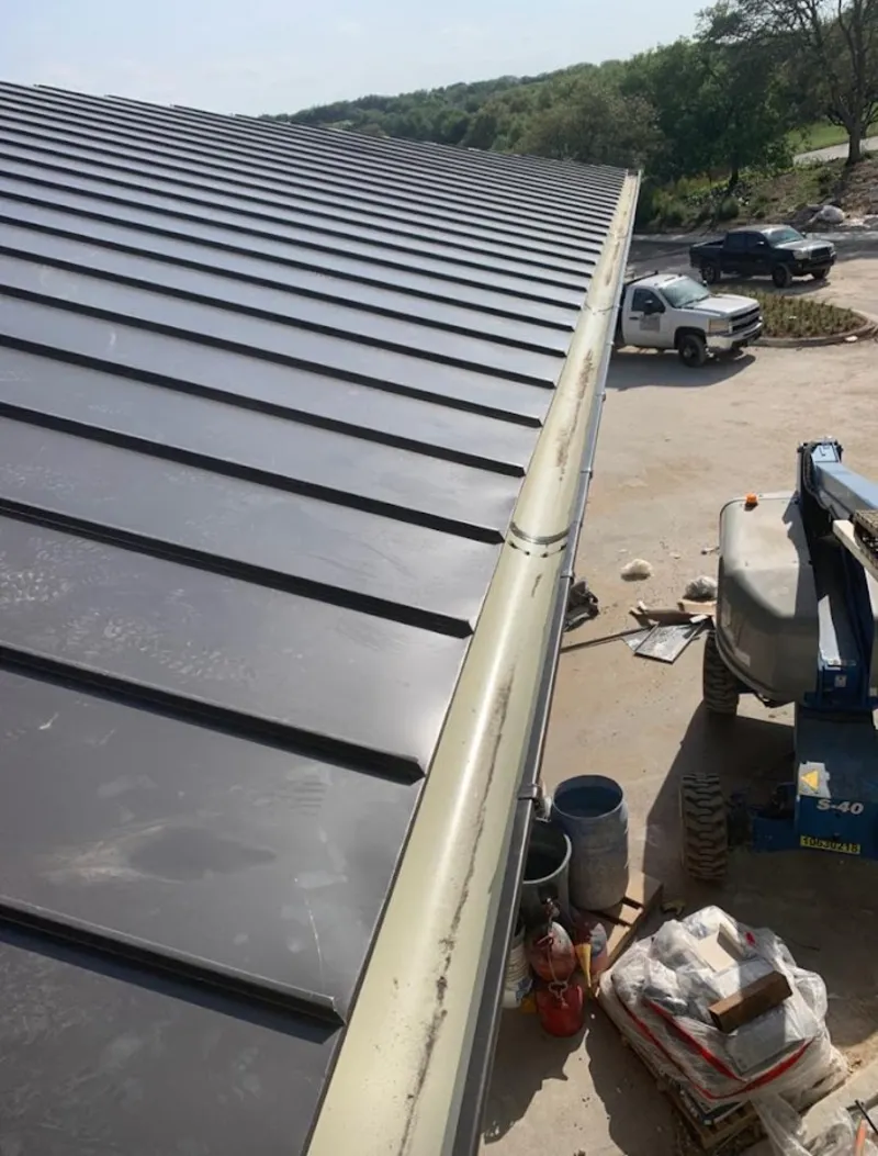 Standing seam panel and gutter detail on a metal roofing jobsite in North Richland Hills